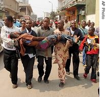 Congolese protester Samba Patou is carried to a hospital by other protesters after being beaten by police during a demonstration in Kinshasa, July 11, 2006